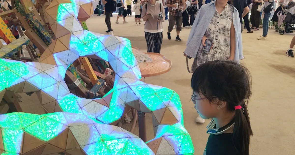 EXPO2025 クラゲ館|光と音で反応する『創造の木』を見つめる子ども(予約不要の体験エリア)